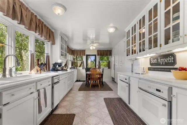 Light-filled kitchen with classic charm, abundant storage, and extensive counter space—ideal for cooking, gathering, and morning coffee with a view.