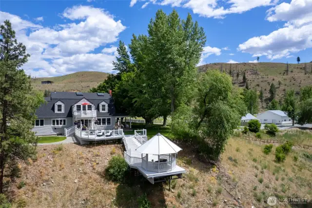 Deck View: The riverside deck and gazebo overlook a scenic river valley, offering an idyllic setting for outdoor living and gracious entertaining.