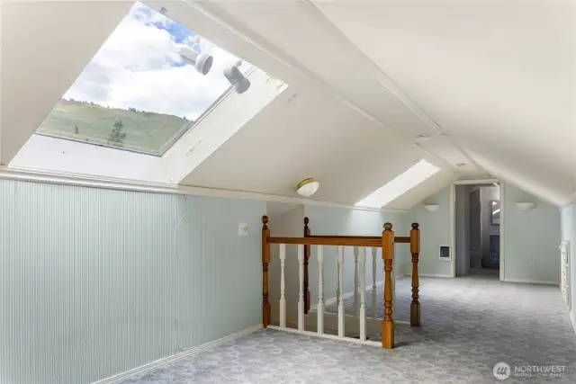 Charming finished attic with skylights and mountain views—includes ½ bathroom, extra bunk room, storage or play room.