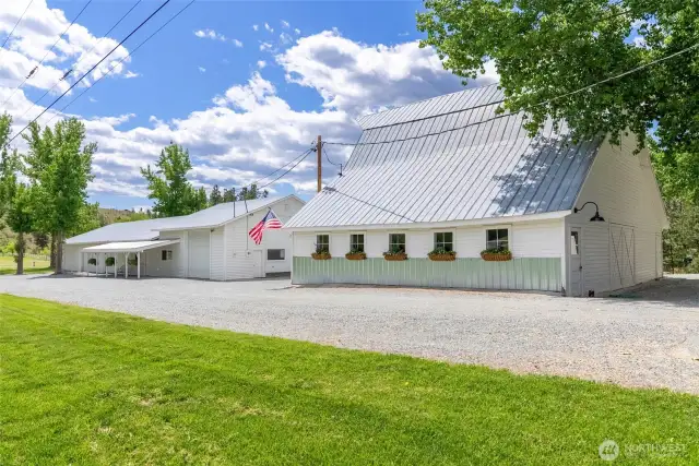 Charming historic barn with metal roof and flower boxes—perfect for storage, animals, or hobby use, all framed by sweeping mountain views and timeless rural character.