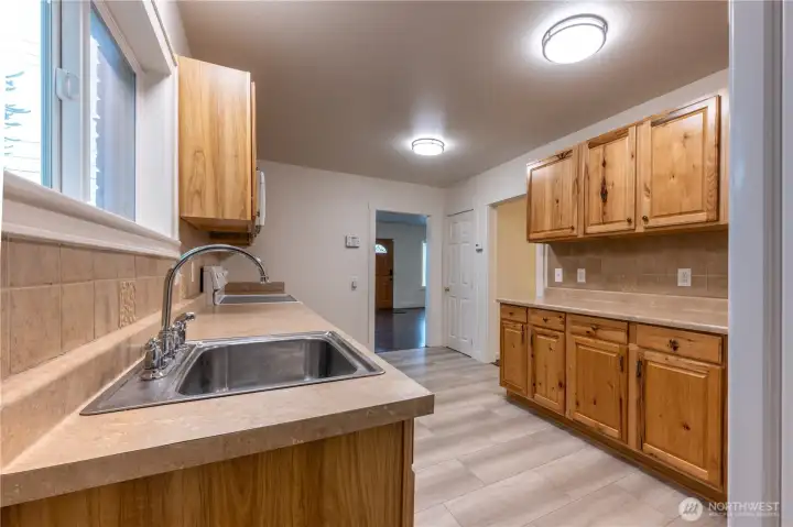 The first door on the right leads to the full bath and a main floor bedroom, the second door is a walk in pantry, and then straight ahead is the dining room and living room.