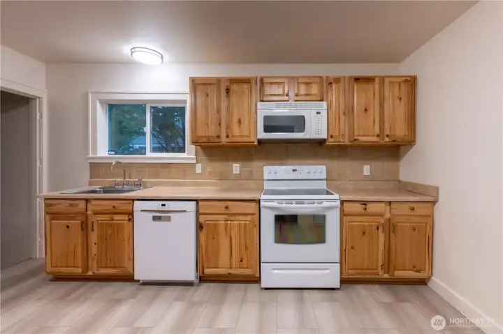 Bosch dishwasher and nice floors, along with crisp white appliances adorn the kitchen.