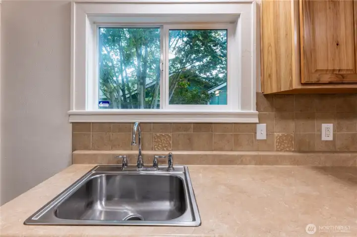 Clean counters and tile backsplash grace this space.
