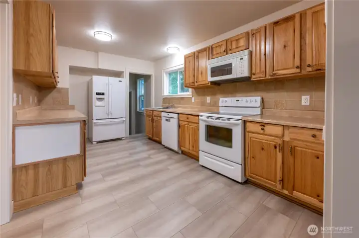 The kitchen is delightful to cook in, even with multiple chefs.  Through the door by the fridge is the large mudroom/laundry room, and stairs to the lower level.  Let's head down.