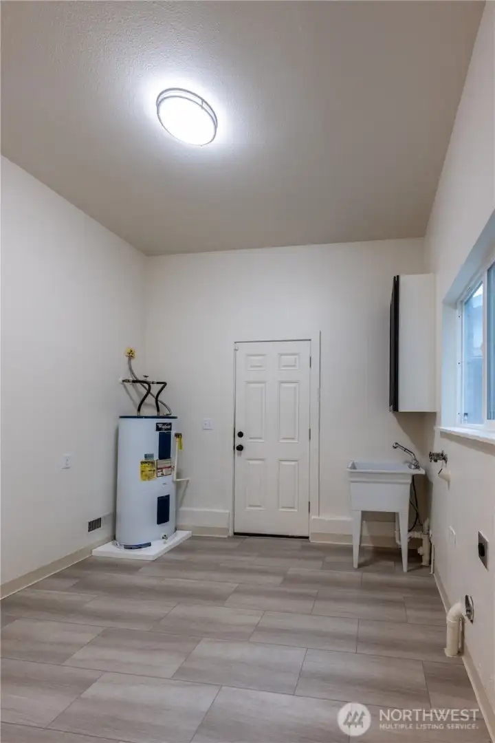 Washer/dryer hookups and a sink make this mud room, with a door to the back yard and rear building, convenient AND helps to keep the main floors tidy.  Plus, there's tons of extra room for what your lifestyle needs.