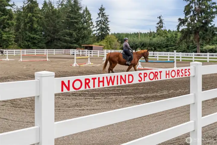 Up-close look at the outdoor arena, beautifully enclosed with vinyl fencing for a clean, polished appearance. The arena features high-quality sand footing, providing optimal traction and comfort for horses during training or exercise.