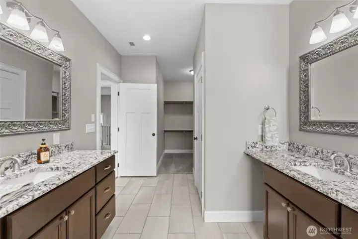 Primary bathroom with dual vanities.
