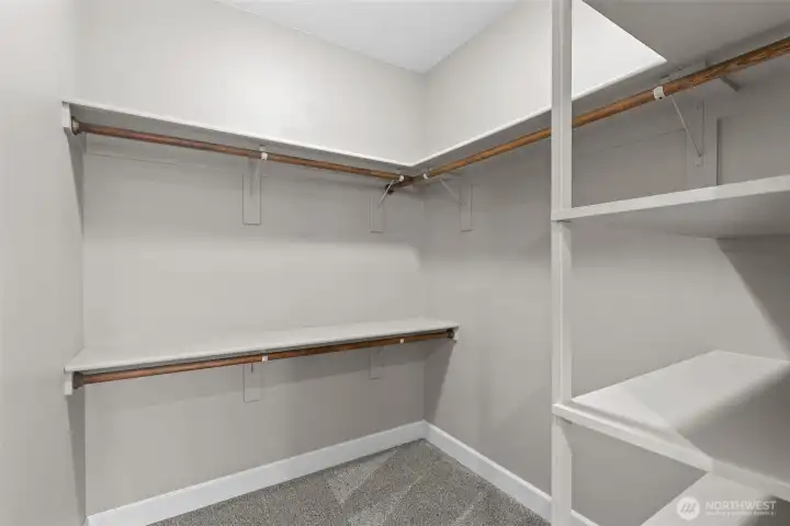 Walk in closet off primary bathroom with shelves.