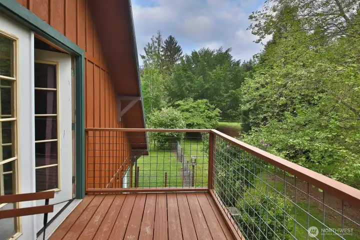 Deck off the primary bedroom with tranquil views of the lake Deck off the primary bedroom with tranquil views of the lake
