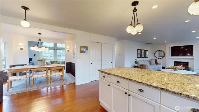 Photo from kitchen looking at dining room, doors to pantry, and through eating area to family room