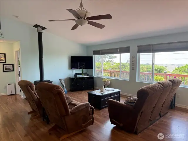 Living room area is bright and airy with laminate flooring for low maintenance. Note ceiling fan.
