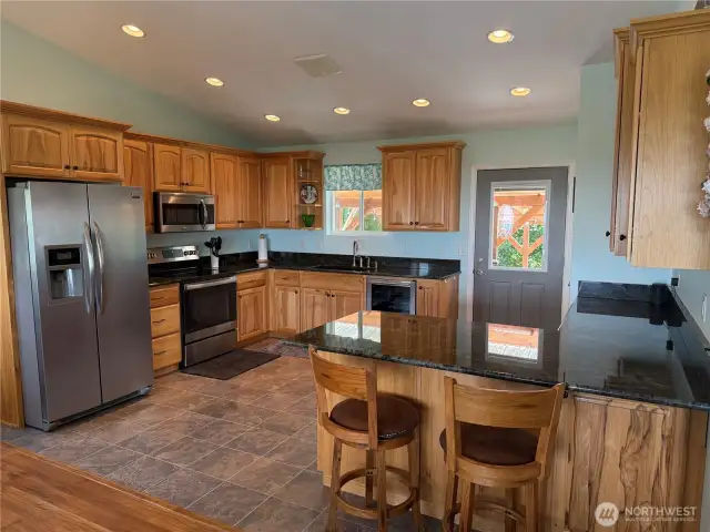 The kitchen has custom cabinets, stainless steel appliances, and a wine cooler.  Is plumbed for dishwasher in place of the wine cooler if so desired.