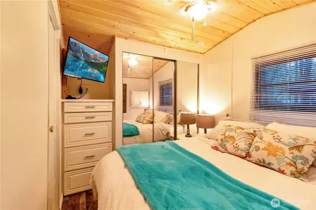 Built in dresser and wall mounted TV in primary bedroom