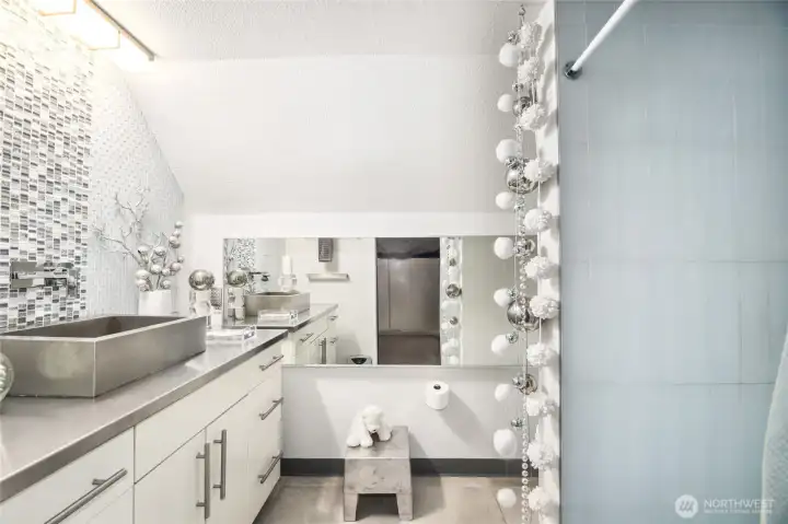 ¾ Bath  Walk-In Closet with built-ins, lots of hanging space and cabinets with shelves  Bathroom:     Walk-in shower with glass tile and custom niches     Single vanity with glass tile backsplash detail, stainless-steel sink, and custom stainless-steel counter      Large horizontal mirror