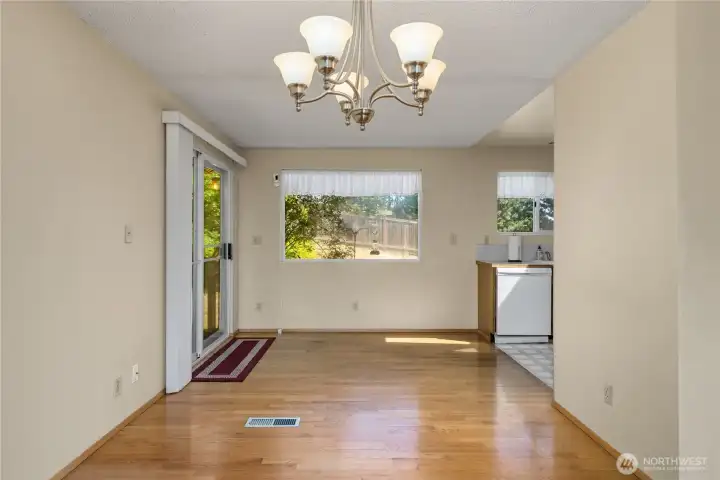 Light filled dining area with hardwood floors.