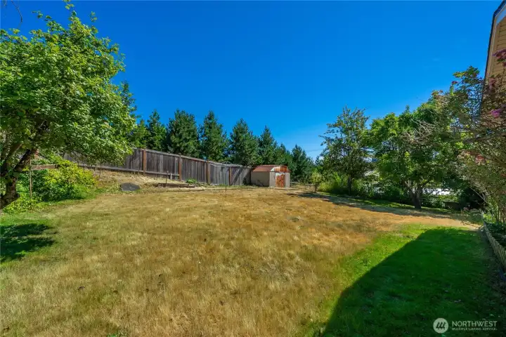 Gently sloping backyard with garden space.