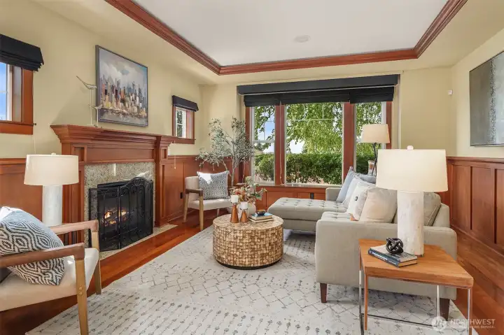 Rich millwork, a gas fireplace, and walls of windows create a warm, inviting gathering space filled with natural light and timeless Craftsman character. Rich millwork, a gas fireplace, and walls of windows create a warm, inviting gathering space filled with natural light and timeless Craftsman character.