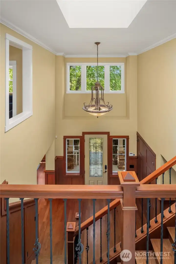 A dramatic two-story foyer welcomes guests with soaring ceilings, rich Craftsman millwork, warm hardwood floors, and abundant natural light. A dramatic two-story foyer welcomes guests with soaring ceilings, rich Craftsman millwork, warm hardwood floors, and abundant natural light.