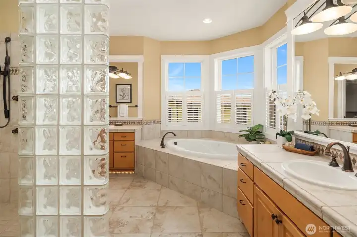 Designed with a spa-inspired sensibility, the primary bath features dual vanities, a soaking tub, oversized walk-in shower, and abundant natural light. Designed with a spa-inspired sensibility, the primary bath features dual vanities, a soaking tub, oversized walk-in shower, and abundant natural light.
