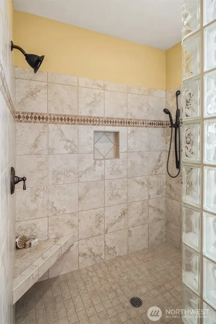 Spa-worthy finishes include an expansive walk-in shower accented by glass-block walls that fill the space with soft natural light. Spa-worthy finishes include an expansive walk-in shower accented by glass-block walls that fill the space with soft natural light.