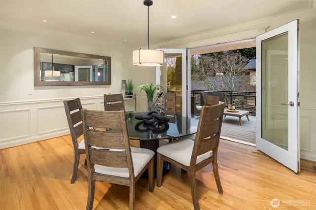 Classical wainscotting adorn this fabulous dining room. Bring the outdoors in! French doors open up to the outdoor balcony for an easy flow.