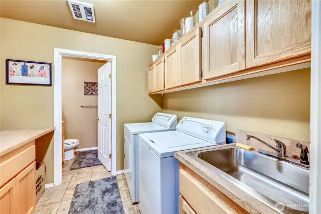 3rd bathroom on the lower level through the laundry area. Nice laundry room has a sink and storage space.