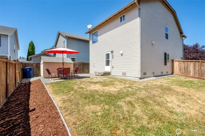 Rear yard is "L" shaped with a storage shed, area for a table and garden beds ready for your creativity. Gate on the far side.