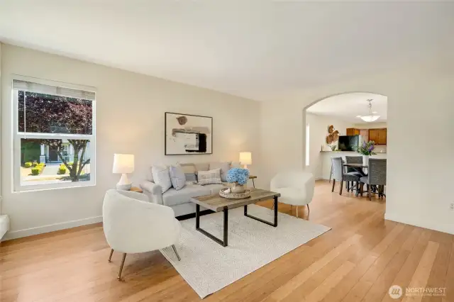Living room with double arched entry to the kitchen and dining area.