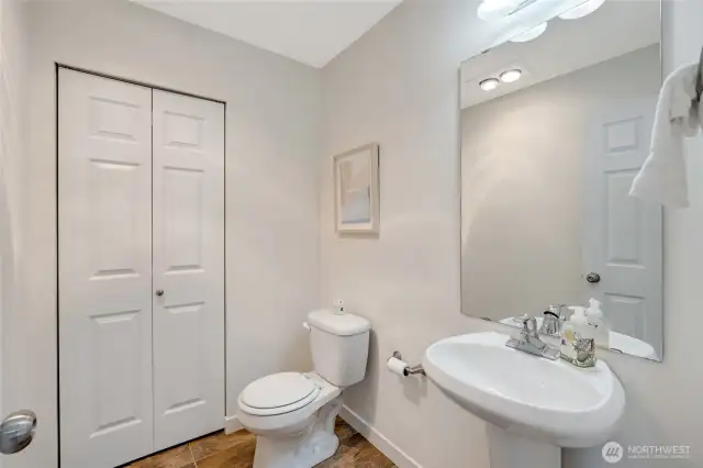 Half bathroom on main with closet. Closet holds the hot water heater and additional shelving for storage.