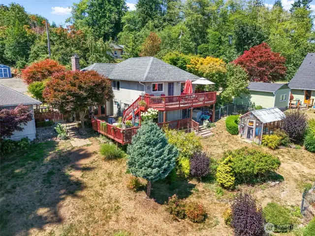 Exterior over view of home, garage and greenhouse.  Fenced Garden area in bottom left of the yard but not in photo.  Also has gate for alley access