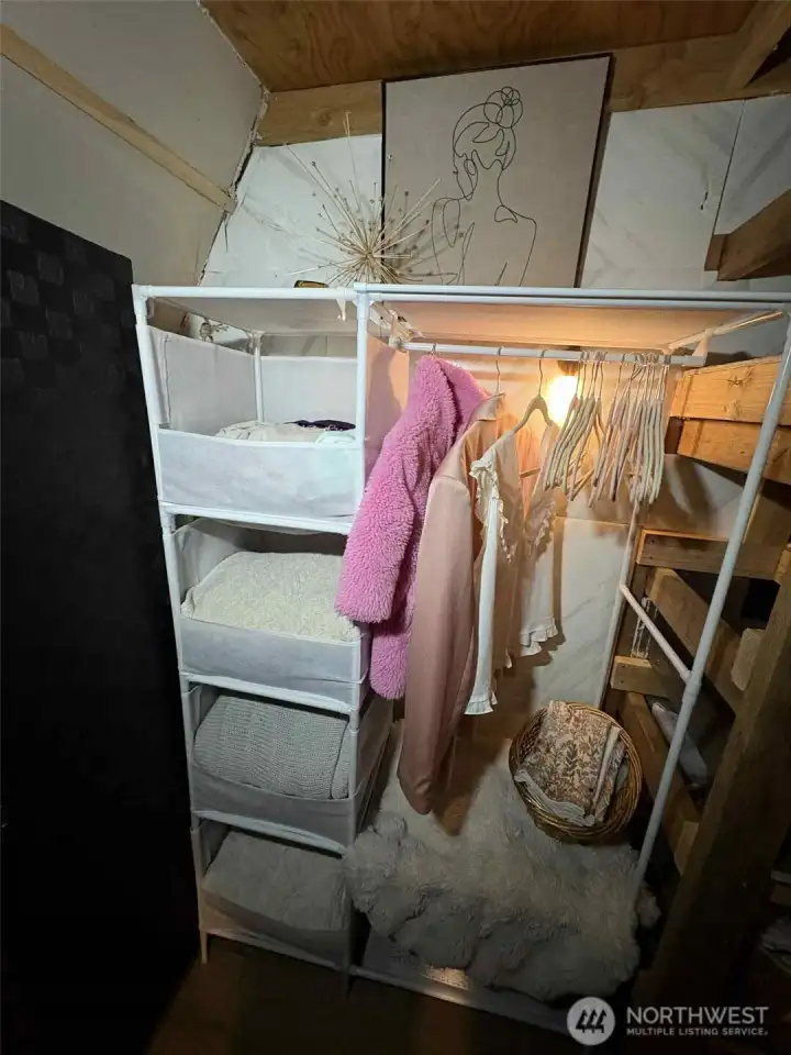 Closet stays. Tucked behind staircase. Rechargeable Lighting installed behind.