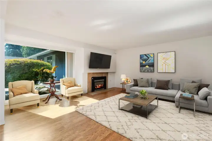 Large open Living area with big picture window. Plenty of natural light. Gas Fireplace. (Virtual staging used)