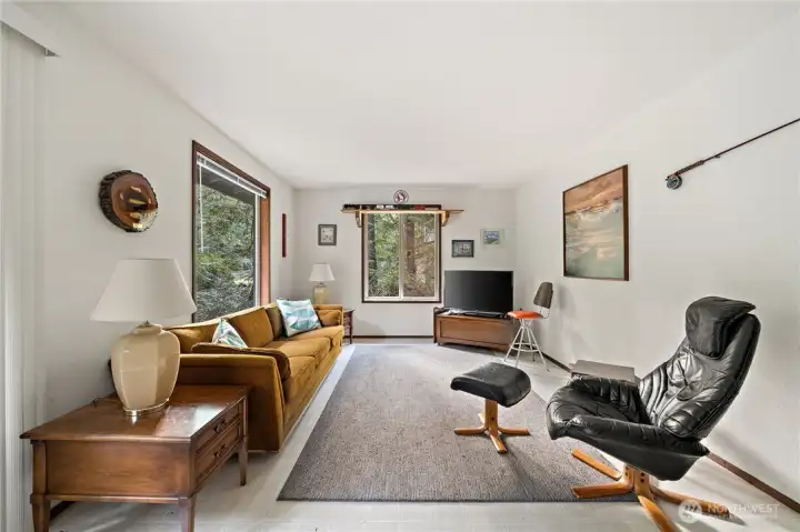 Living room has slider to deck on right, hallway to bedrooms on left.
