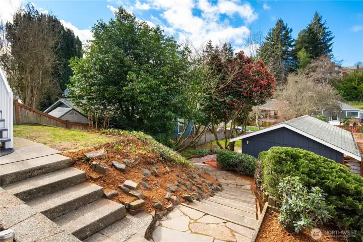 The flagstone path leads down from the house to the lower lot area and garage.