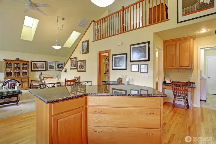View from the kitchen into the living room while looking up at the loft space above.