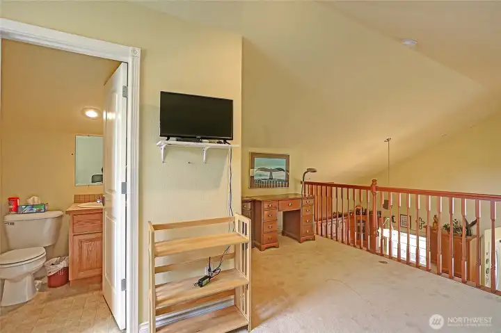 The loft serves as a spacious bedroom with a full bathroom.