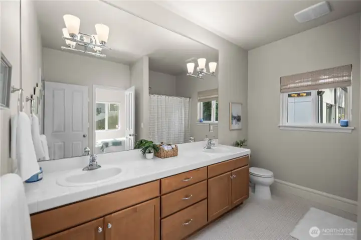 The upper-level shared guest bathroom features a double vanity, making busy morning routines more convenient and functional for family members and guests.