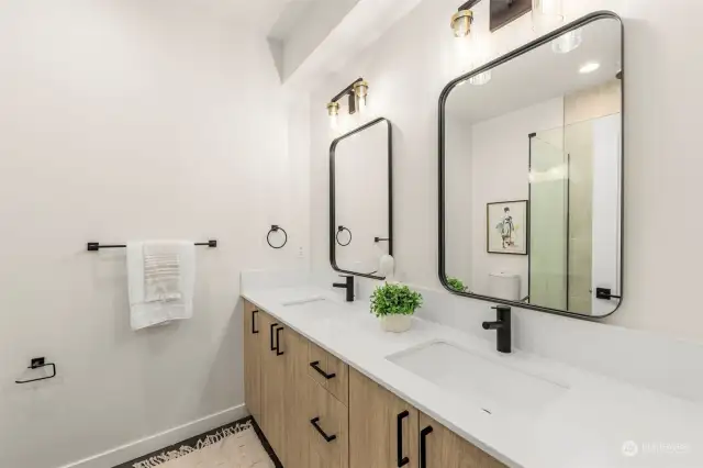 A sleek double vanity offers plenty of space for morning routines. This bathroom has stylish mirrors and contemporary fixtures and is all about modern elegance.