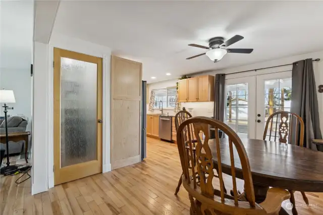 Open kitchen/dining area with french doors and walk-in pantry. New custom trim throughout home.