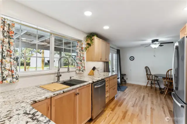 View window over deep sink with quality fixture and veggie cutting board.