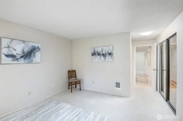 If you look to the right, you can see the large closet in primary bedroom, with hanging racks and shelving inside.