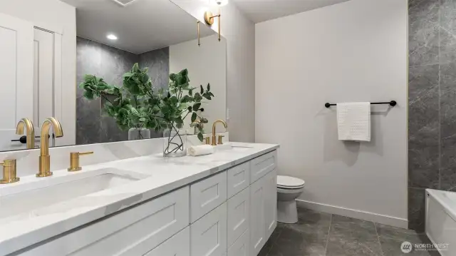 Main Bath has quartz counters, undermount sinks, & tile flooring.