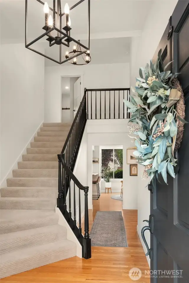 Inviting hardwoods, open rail banister and vaulted ceilings adorn the entry.
