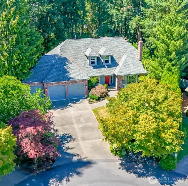 Aerial view showing the long, broad driveway leading to the 3-car garage.