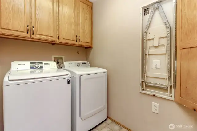 Handy laundry room with storage cabinets - even a hideaway ironing board!