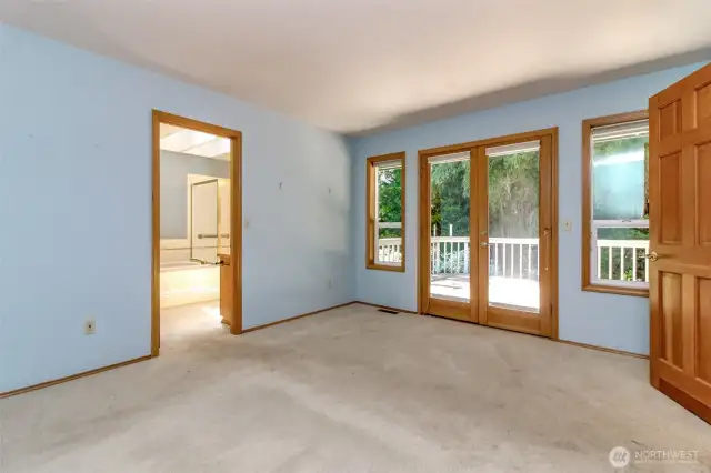 Primary bedroom with doors leading out to the back deck.