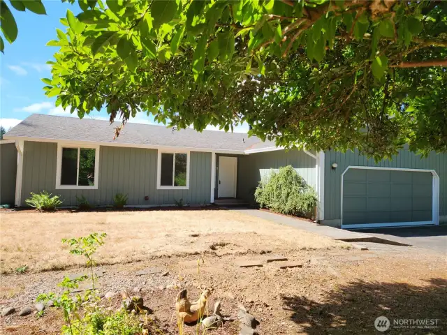 Front view of home under the shade of a Magnolia tree in front yard.