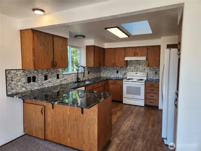 Kitchen w/granite countertops and plenty of room for any cook! Notice the skylight above, which allows so much light in this space!