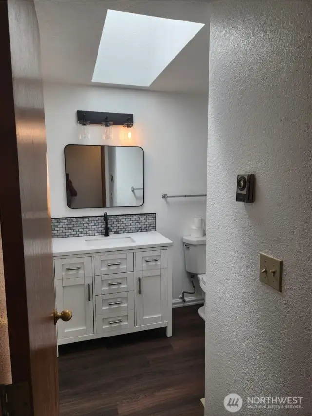 Beautifully updated guest bath with nice sized vanity for storage. Another skylight allowing so much light in the bathroom.