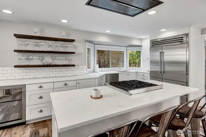 High end appliances including Sub Zero and Wolf. Notice the wine cooler on the left of this photo. Also note the built in vent hood into the ceiling. Quartz counters and soft close drawers